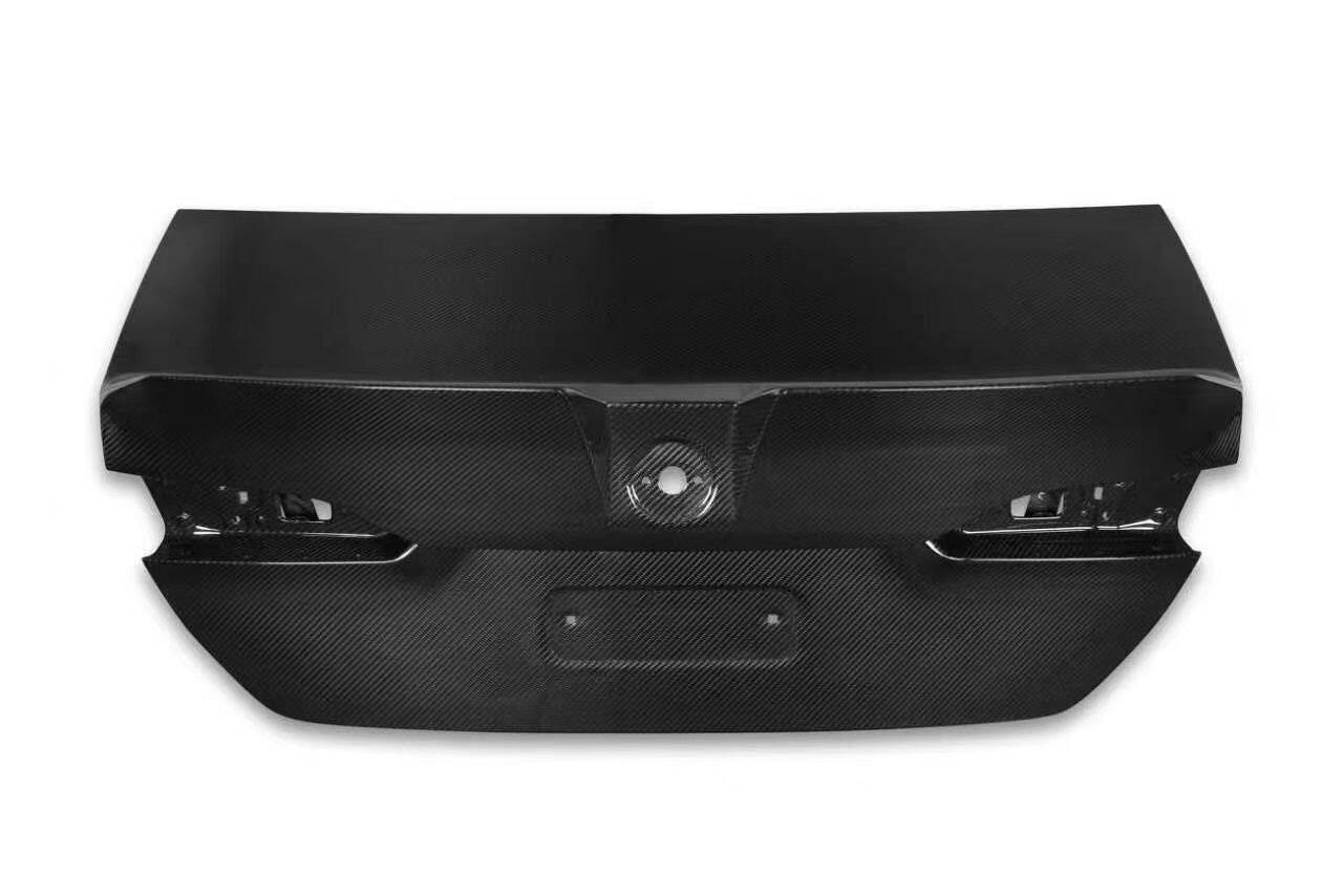 A black carbon fiber textured rear trunk lid for a BMW 5 Series (G60/G68), shown from a top-down perspective on a white background.