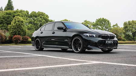Black BMW car on a road with trees in the background